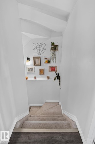 Carpeted staircase with white trim, leading to wood-finish flooring - 833 Mcallister Crescent Sw, Edmonton, AB - Indoor Photo Showing Other Room