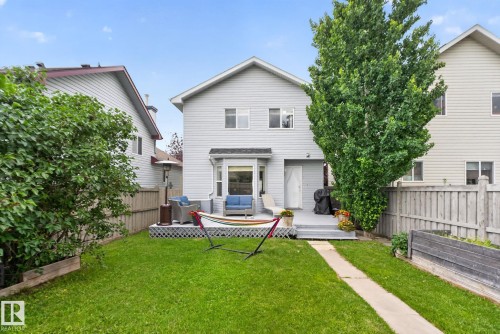 Expansive backyard featuring a manicured lawn and mature trees - 833 Mcallister Crescent Sw, Edmonton, AB - Outdoor With Deck Patio Veranda