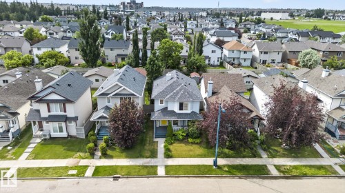 Suburban streetscape featuring a collection of detached homes with varied architectural styles, asphalt shingle roofs, and established landscaping - 833 Mcallister Crescent Sw, Edmonton, AB -  With Facade