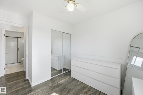 Room featuring wood-finish flooring, a ceiling fan with integrated lighting, and white walls - 15111 67 Street Nw, Edmonton, AB - Indoor Photo Showing Other Room