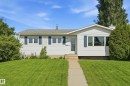 White siding exterior with blue window shutters, gray shingle roof, and a concrete walkway leading to the front entry - 15111 67 Street Nw, Edmonton, AB  - Outdoor 