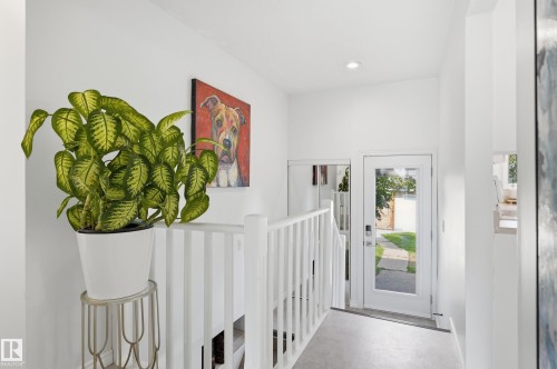 Hallway featuring light gray flooring, white walls, recessed lighting, and a white staircase with vertical balusters - 15111 67 Street Nw, Edmonton, AB - Indoor Photo Showing Other Room