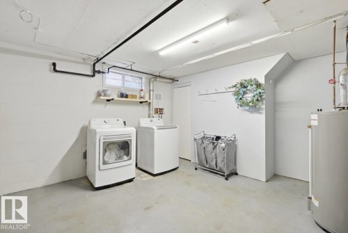 Dedicated utility space featuring a window, built-in shelving, and a wall-mounted coat rack - 15111 67 Street Nw, Edmonton, AB - Indoor Photo Showing Laundry Room