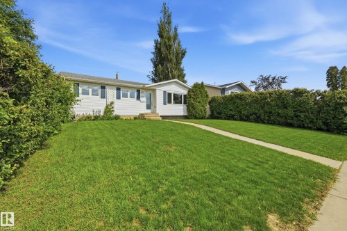 Single-story residence featuring white siding, dark shutters, and a prominent front lawn - 15111 67 Street Nw, Edmonton, AB - Outdoor