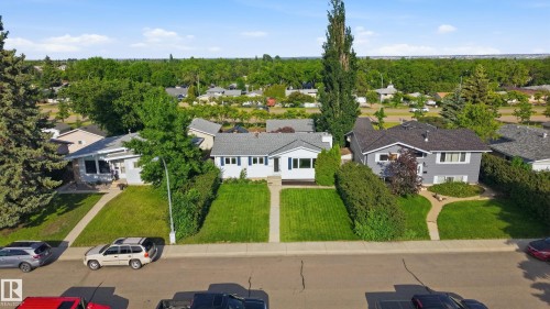 Single-story residence featuring white siding, a dark roof, and blue shutters - 15111 67 Street Nw, Edmonton, AB - Outdoor