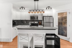 Kitchen featuring white cabinetry, dark countertops, and stainless steel appliances - 