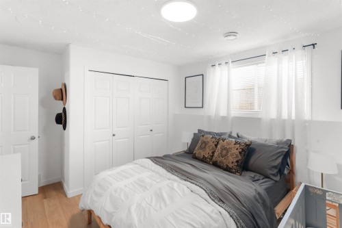 Bedroom featuring light wood-finish flooring and a window with blinds and sheer curtains - 679 Kananaskis Drive, Devon, AB - Indoor Photo Showing Bedroom