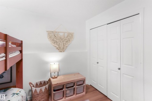White bi-fold closet doors with silver-tone hardware - 679 Kananaskis Drive, Devon, AB - Indoor