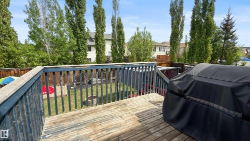 Spacious wooden deck overlooking a fenced backyard with mature trees - 679 Kananaskis Drive, Devon, AB - Outdoor With Deck Patio Veranda With Exterior