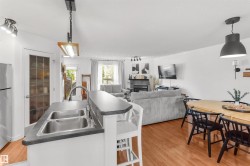 Kitchen island featuring a double-bowl stainless steel sink with a high-arc faucet, ample counter space, and integrated seating - 