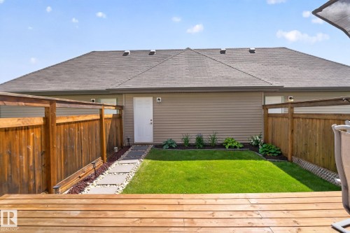 Private backyard featuring a wooden deck, a manicured lawn, and a stepping stone path - 319 Desrochers Boulevard Sw, Edmonton, AB - Outdoor With Exterior