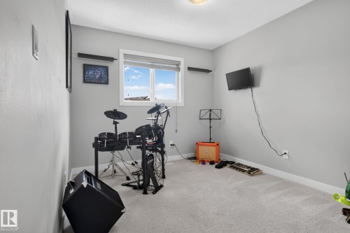 Room featuring a window, light gray painted walls, and light-colored carpet flooring - 319 Desrochers Boulevard Sw, Edmonton, AB - Indoor Photo Showing Gym Room