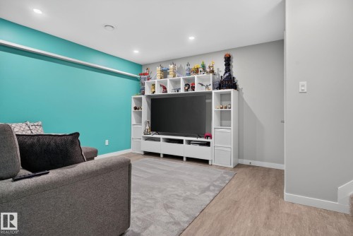 Entertainment room featuring recessed lighting, a built-in media center with shelving, and wood-finish flooring - 319 Desrochers Boulevard Sw, Edmonton, AB - Indoor