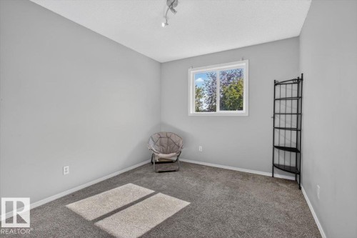 Room featuring light gray walls, gray carpeting, and a white window frame - #18 345 Kirkness Rd Nw, Edmonton, AB - Indoor