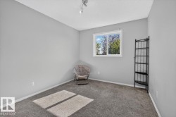 Room featuring light gray walls, gray carpeting, and a white window frame - 