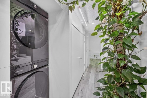 Vertical laundry appliances with front-loading design - #18 345 Kirkness Rd Nw, Edmonton, AB - Indoor Photo Showing Laundry Room