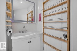 Bathroom vanity featuring a vessel sink, chrome faucet, and white cabinet storage - 
