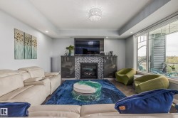 Living room featuring a fireplace with a tiled surround, built-in cabinetry, and wood-finish flooring - 