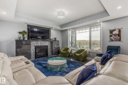 Living room featuring a modern fireplace with mosaic tile surround, built-in cabinetry, and a large window - 