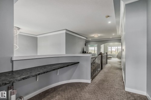 Upper level hallway featuring a decorative built-in shelf, carpet flooring, recessed lighting, and a metal railing - 4104 8 Street Nw, Edmonton, AB - Indoor Photo Showing Other Room