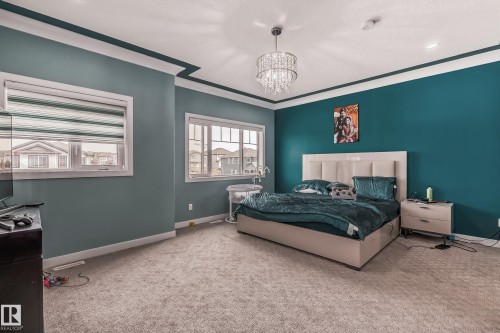 Carpeted room featuring a ceiling chandelier, recessed lighting, and crown molding - 4104 8 Street Nw, Edmonton, AB - Indoor Photo Showing Bedroom