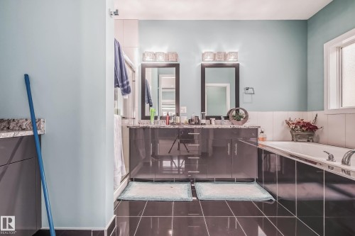 Bathroom featuring a double vanity with grey cabinetry and stone countertops - 4104 8 Street Nw, Edmonton, AB - Indoor Photo Showing Bathroom