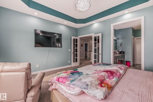 Recessed lighting illuminates a tray ceiling with a contrasting accent color - 4104 8 Street Nw, Edmonton, AB - Indoor Photo Showing Bedroom