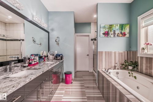 Bathroom featuring a dual vanity with a granite countertop, undermount sinks, and contemporary faucets - 4104 8 Street Nw, Edmonton, AB - Indoor Photo Showing Bathroom