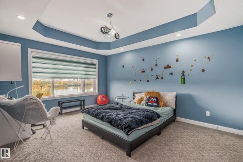 Spacious room with a large window, tray ceiling, recessed lighting, and carpeted flooring - 4104 8 Street Nw, Edmonton, AB - Indoor Photo Showing Bedroom