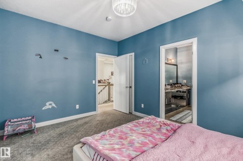 Carpeted room with blue walls, a ceiling-mounted light fixture, and white trim - 4104 8 Street Nw, Edmonton, AB - Indoor Photo Showing Bedroom