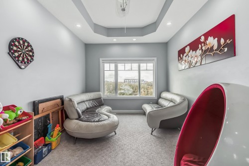 Recessed ceiling lighting illuminates a room featuring a tray ceiling detail and neutral wall paint - 4104 8 Street Nw, Edmonton, AB - Indoor