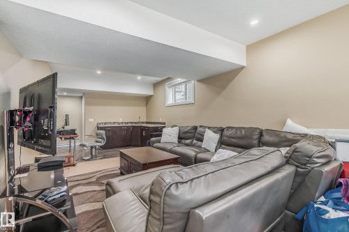 Finished basement space featuring recessed lighting and a wet bar with dark wood cabinetry and a stone-finish countertop - 4104 8 Street Nw, Edmonton, AB - Indoor
