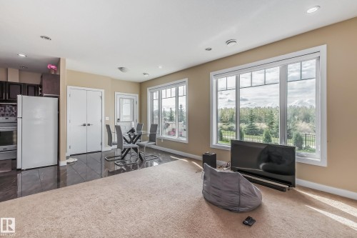 Open-concept living area with large windows, recessed lighting, and a neutral color palette - 4104 8 Street Nw, Edmonton, AB - Indoor