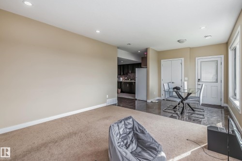Open-concept living area featuring a neutral wall color, recessed lighting, and a combination of carpet and polished tile flooring - 4104 8 Street Nw, Edmonton, AB - Indoor