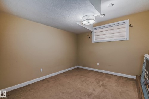 Carpeted room featuring neutral-toned walls, white trim, and a contemporary flush-mount ceiling light - 4104 8 Street Nw, Edmonton, AB - Indoor Photo Showing Other Room