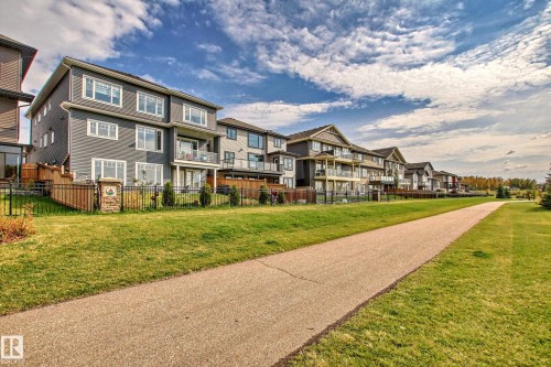 Contemporary multi-story home featuring a dark gray exterior, white trim windows, and a lower-level walk-out patio - 4104 8 Street Nw, Edmonton, AB - Outdoor
