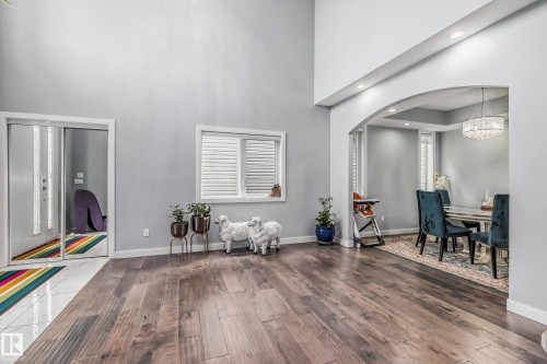 Expansive room featuring rich wood-finish flooring and soaring ceilings - 4104 8 Street Nw, Edmonton, AB - Indoor Photo Showing Other Room