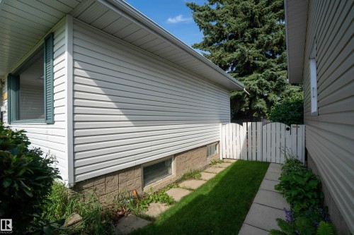 White vinyl siding exterior with stone-look foundation detailing - 5307 105 Street Nw, Edmonton, AB - Outdoor