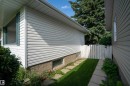 White vinyl siding exterior with stone-look foundation detailing - 5307 105 Street Nw, Edmonton, AB  - Outdoor 