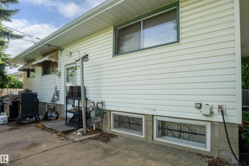 White vinyl siding exterior with an awning-covered entry door - 5307 105 Street Nw, Edmonton, AB - Outdoor With Exterior