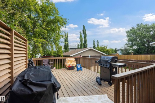 Spacious wood-finish deck with privacy louver panel and sturdy wooden railings - 4810 55 Avenue, Beaumont, AB - Outdoor With Deck Patio Veranda With Exterior
