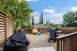 Spacious wood-finish deck with privacy louver panel and sturdy wooden railings - 