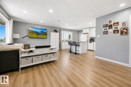 Open-concept living area featuring wood-finish flooring, recessed lighting, and a neutral wall palette - 4810 55 Avenue, Beaumont, AB - Indoor Photo Showing Living Room