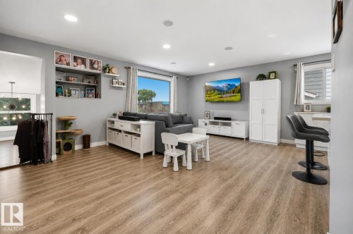 Spacious room featuring wood-finish flooring, recessed lighting, and a large window providing abundant natural light - 4810 55 Avenue, Beaumont, AB - Indoor Photo Showing Other Room