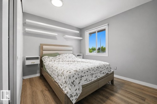 Bedroom featuring wood-finish flooring, a contemporary window, and recessed ceiling lighting - 4810 55 Avenue, Beaumont, AB - Indoor Photo Showing Bedroom