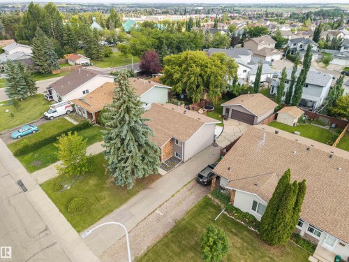 Aerial perspective showcasing the residential neighborhood with a variety of housing styles and mature landscaping - 4810 55 Avenue, Beaumont, AB - Outdoor With View