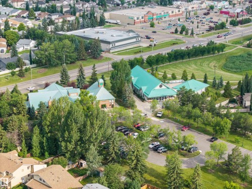 Aerial perspective showcasing multiple buildings with distinct teal-colored roofs - 4810 55 Avenue, Beaumont, AB - Outdoor With View