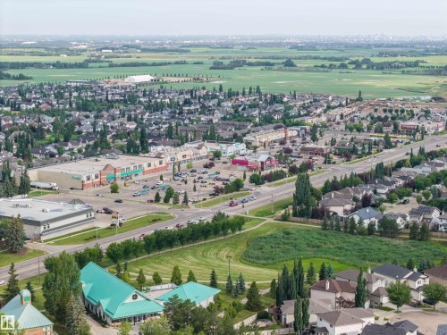 Aerial perspective showcasing residential areas, commercial establishments, and natural green spaces - 4810 55 Avenue, Beaumont, AB - Outdoor With View