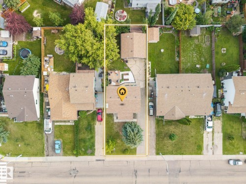 Aerial perspective highlighting a residential property with a paved driveway, front lawn, and established trees - 4810 55 Avenue, Beaumont, AB - Outdoor With View