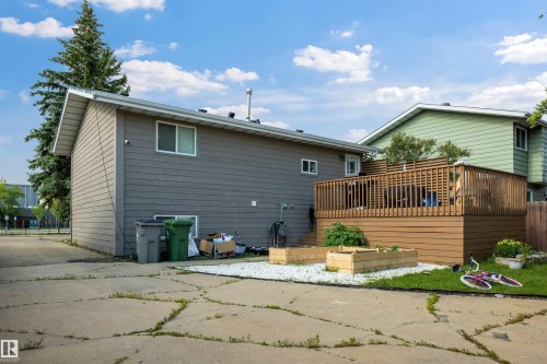 Rear exterior with horizontal siding, featuring a multi-level wooden deck with lattice detailing and a privacy screen - 4810 55 Avenue, Beaumont, AB - Outdoor With Exterior